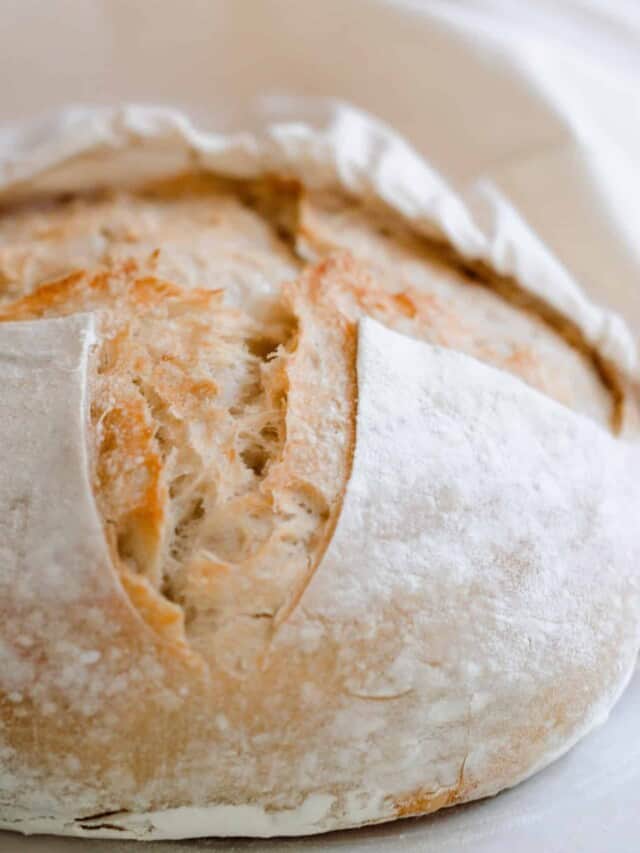 A sourdough loaf being placed in a linen bag