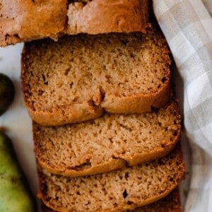 overhead photo of pawpaw bread sliced on a white and tan checked towel