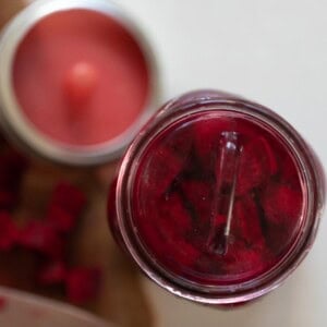 overhead photo of fermented beets in a jar with a silicon fermenting lid to the left.