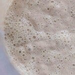 overhead photo of sourdough starter in a glass bowl.