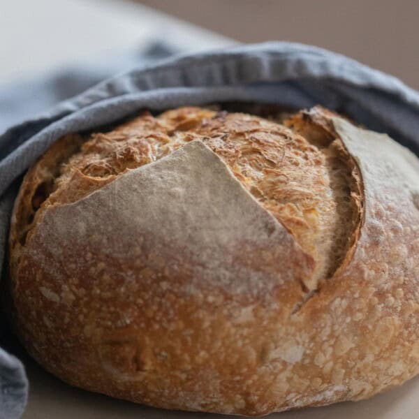 load of garlic sourdough bread wrapped in a blue towel