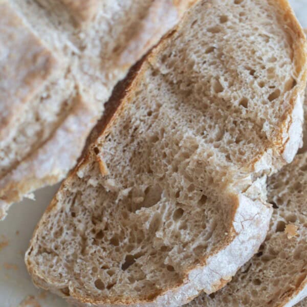 A loaf of sourdough bread baked without a Dutch oven cut into