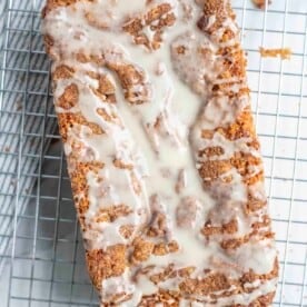 overhead photo of sourdough cinnamon quick bread topped with icing on a cooling rack