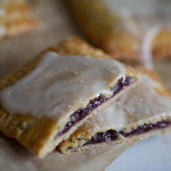 sourdough pop tarts on a parchment lined baking sheet with one cut in half