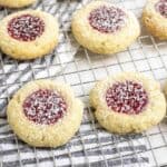 sourdough t thumbprint cookies on a wire rack on top of a black and white stripped towel