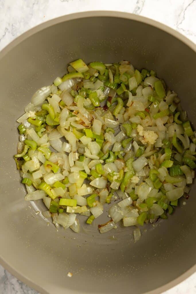 Onions and celery sautéing in a soup pot. 
