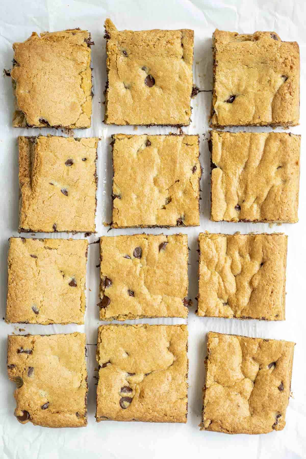 overhead photo of sourdough blondies cut into 12 squares on a marble countertop.