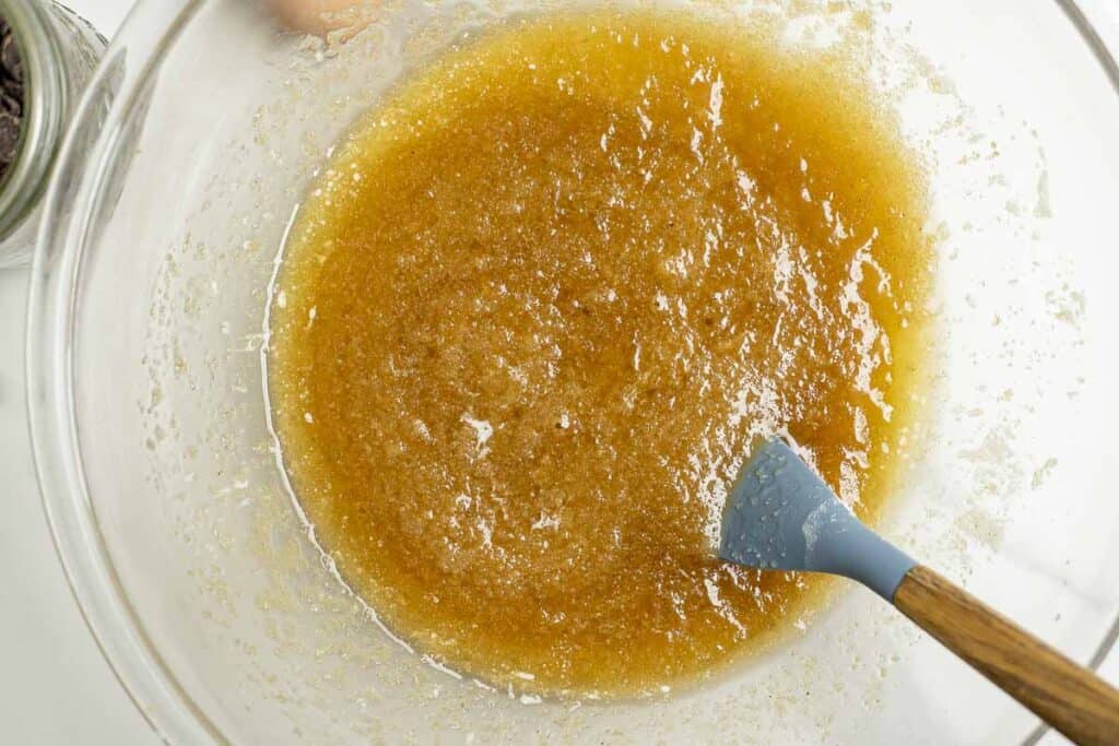 melted butter and sugar in a glass bowl with a spatula