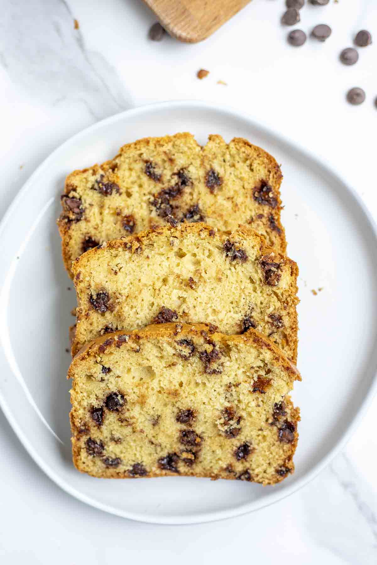 three slices of sourdough chocolate chip bread on a white plate.