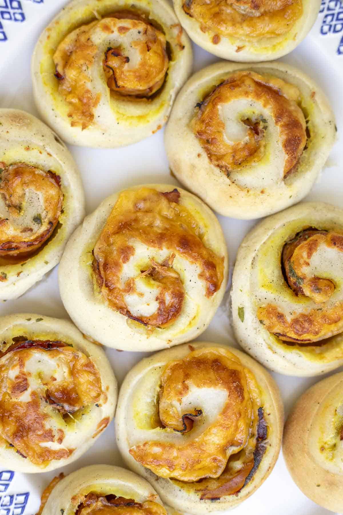 A close up of sourdough ham and cheese rolls on a platter. 