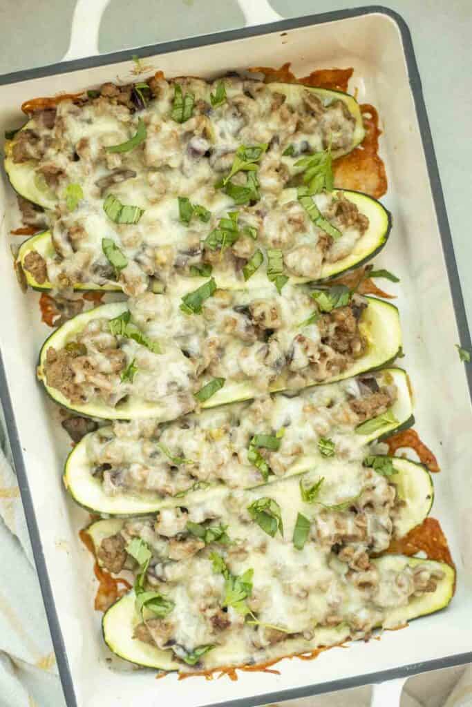 Sausage zucchini boats in a baking dish fresh out of the oven.