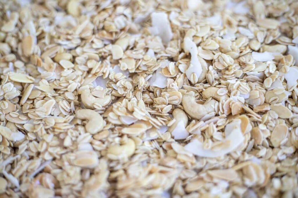 Homemade granola spread out on a baking sheet prior to being baked.