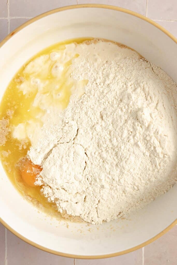 flour, eggs, butter in a white bowl.