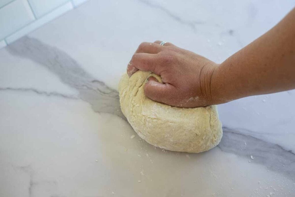 Kneading dough on a marble countertop.