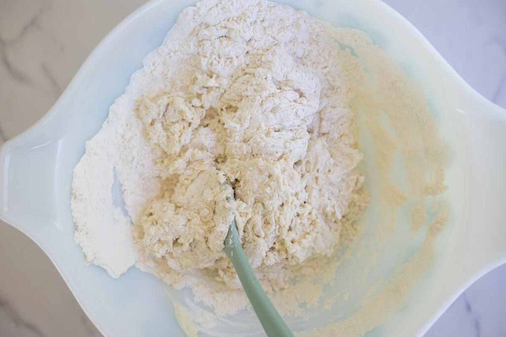 Mixing flour, water, sourdough starter, honey, baking soda, and salt together in a bowl.