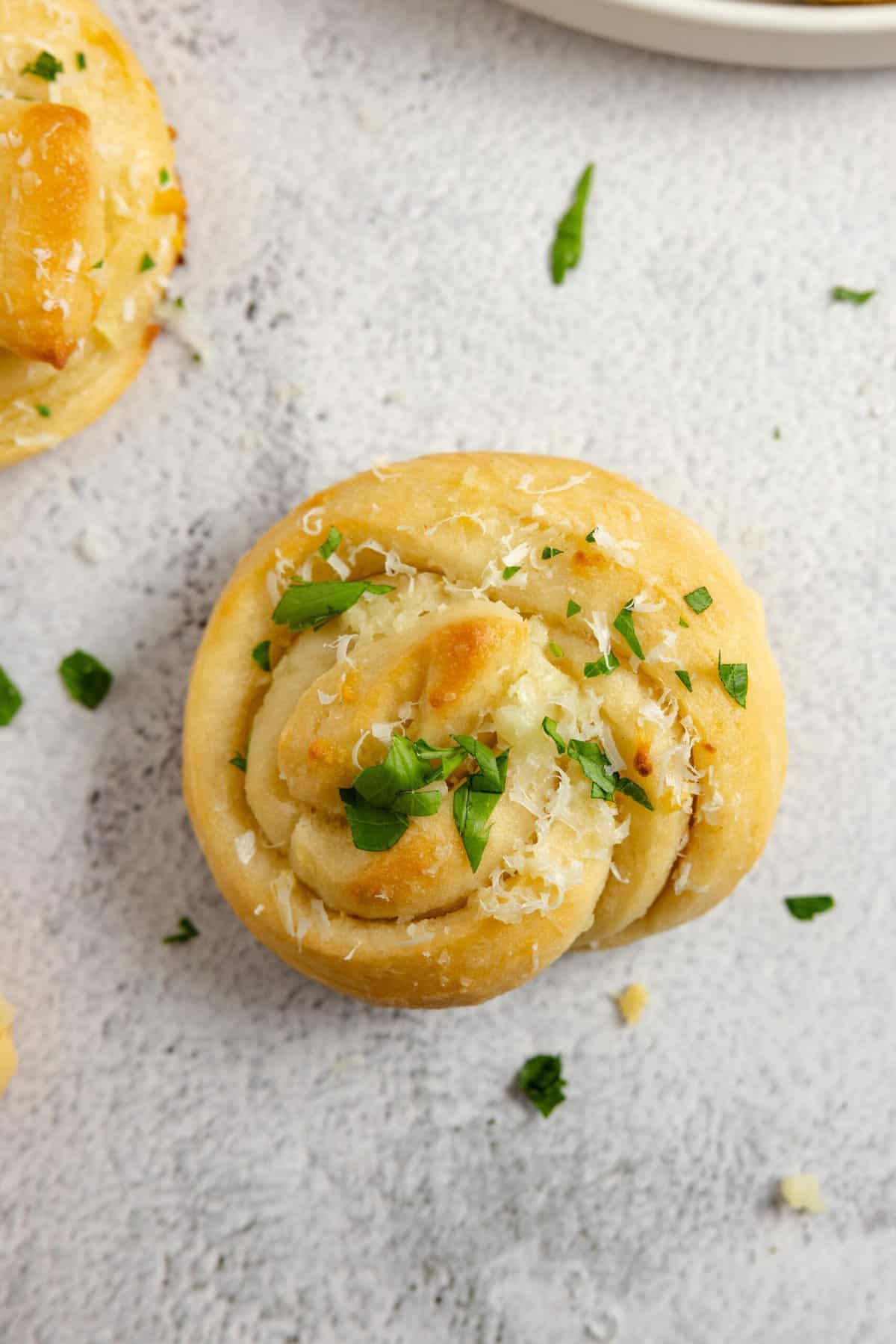 A sourdough garlic knot on a countertop.