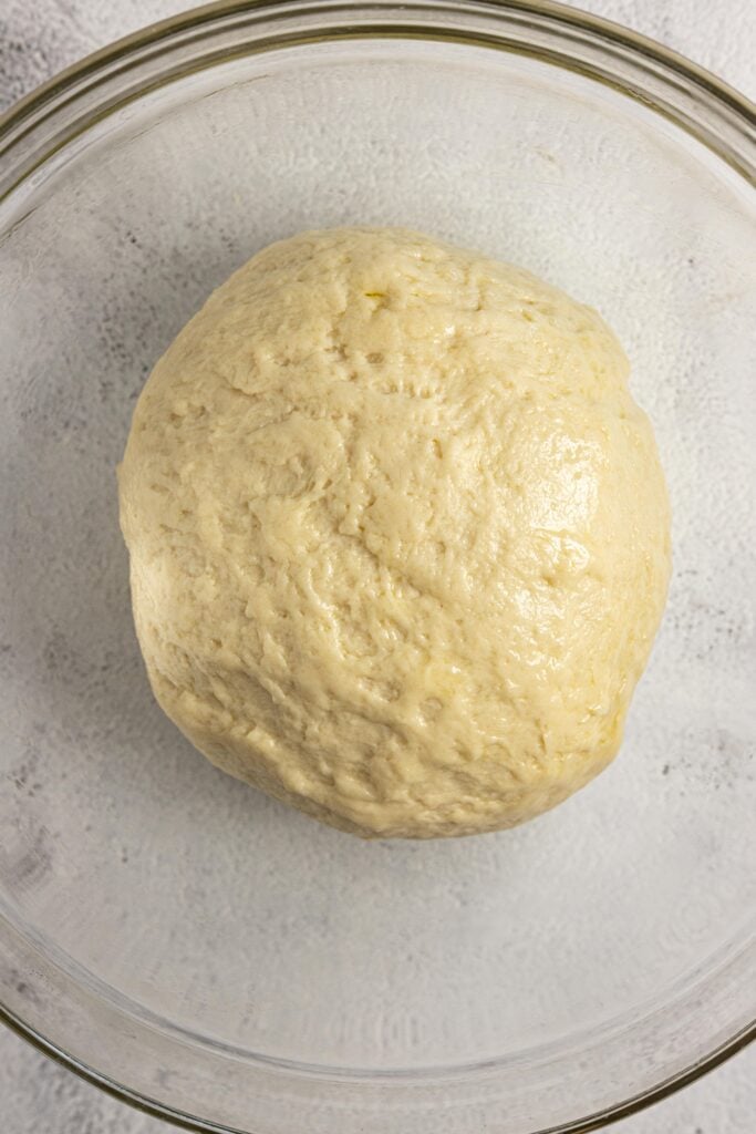 Smooth and glossy dough in a glass bowl.