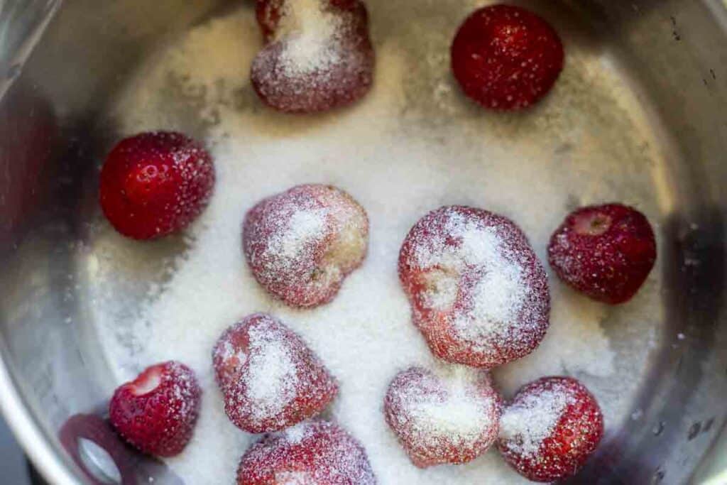 Sugar and strawberries in a saucepan.