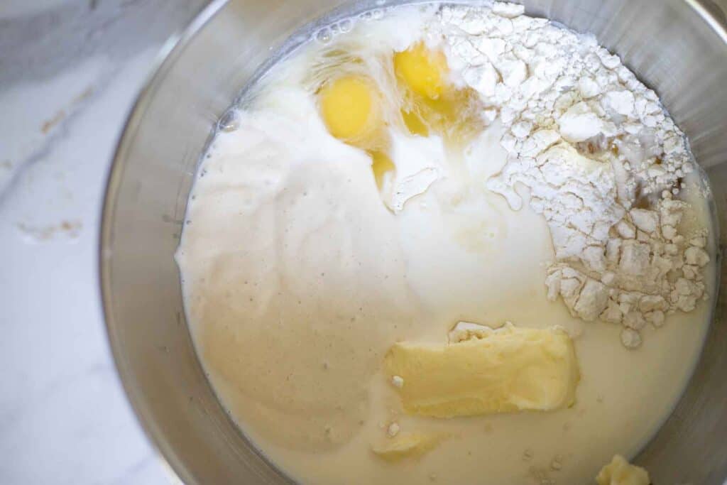 Butter, flour, eggs, milk, sourdough starter, and other ingredients in a bowl.