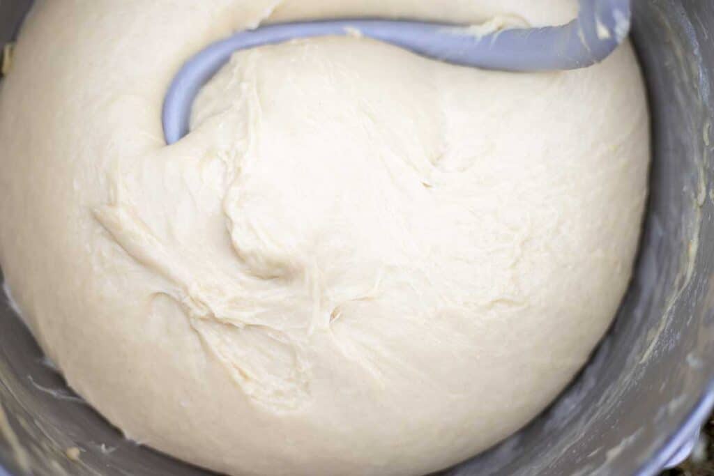 sourdough brioche dough in a stand mixer with a dough hook.