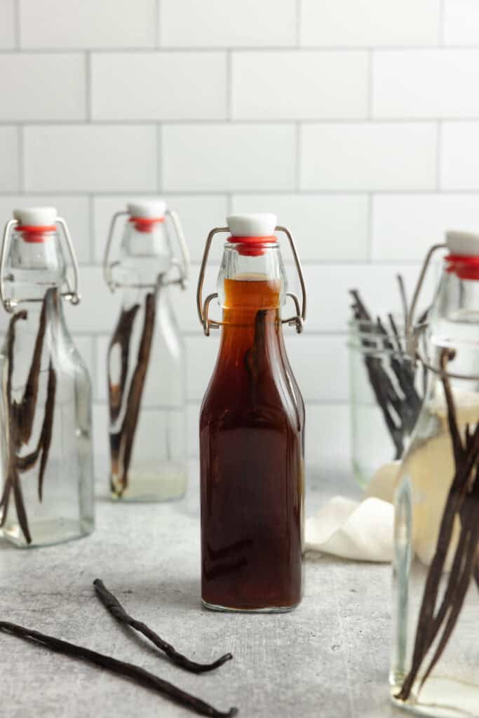 vanilla extract in a bottle surrounded by new extracts being made.