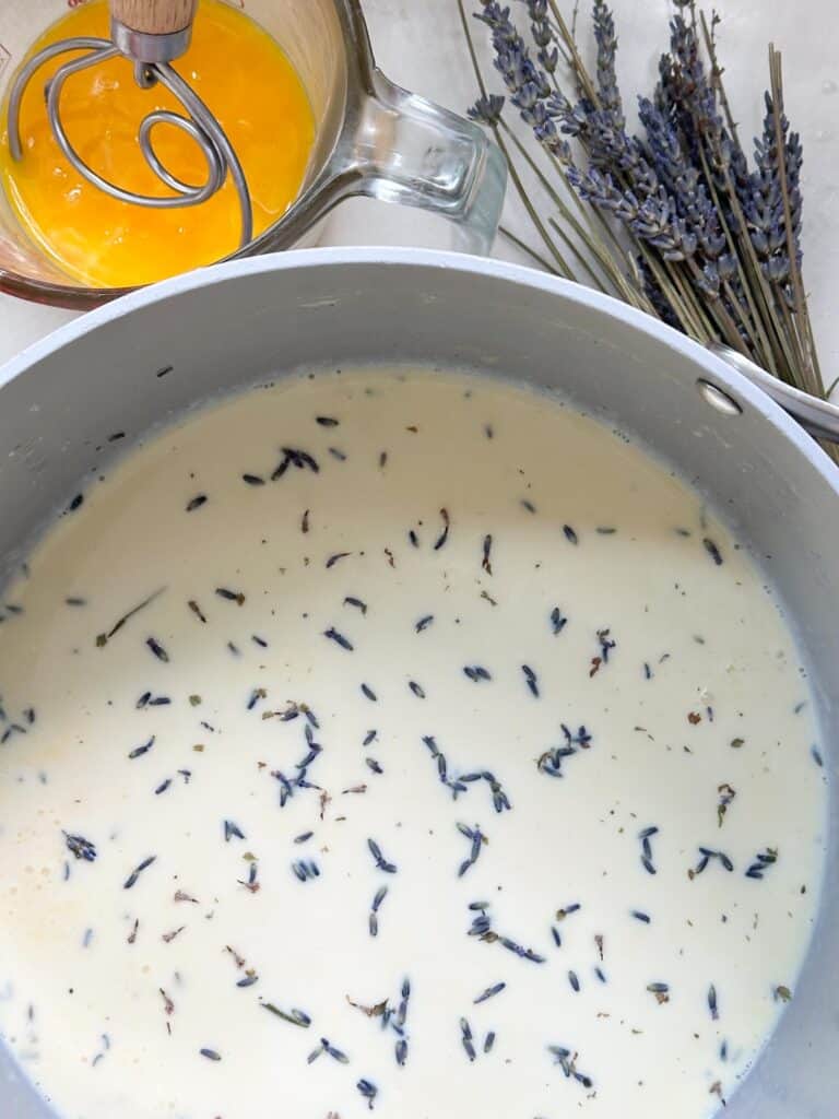 Cream, honey, and lavender petals in a saucepan.