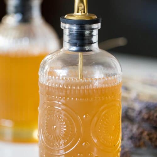 Glass bottle filled with lavender syrup.