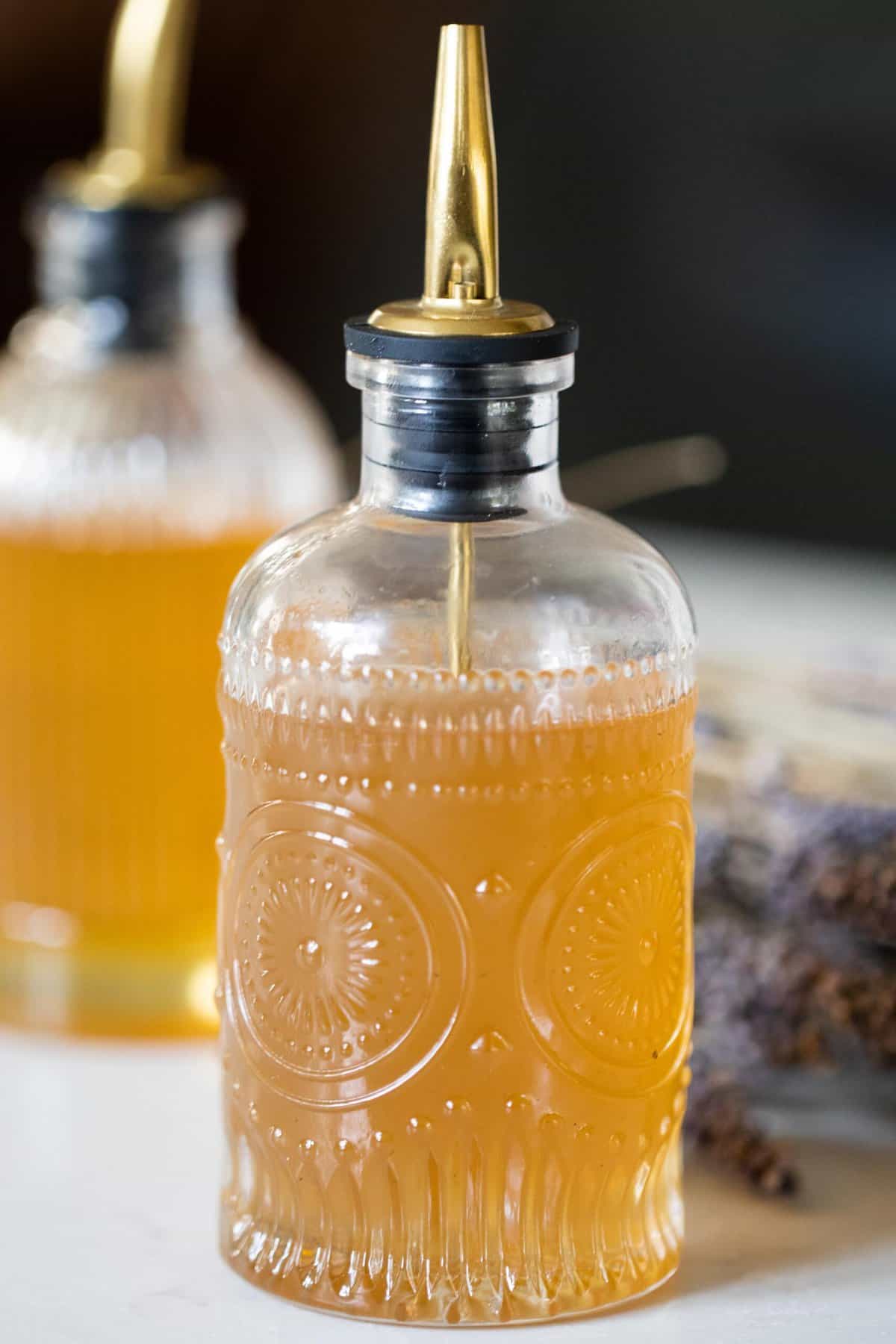 Glass bottle filled with lavender syrup.