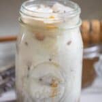 A mason jar filled with an iced lavender latte.