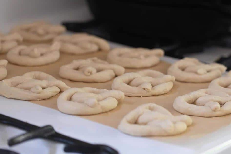 unbaked sourdough pretzels on parchment paper on a oven.