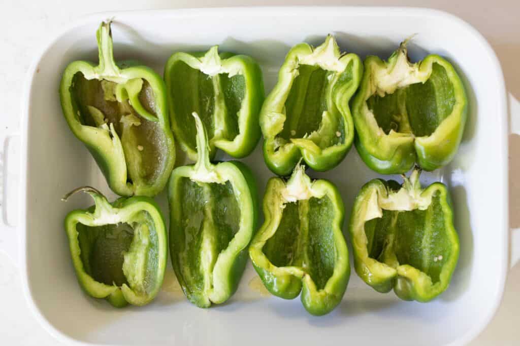 Bell sellers cut in half in a baking dish.