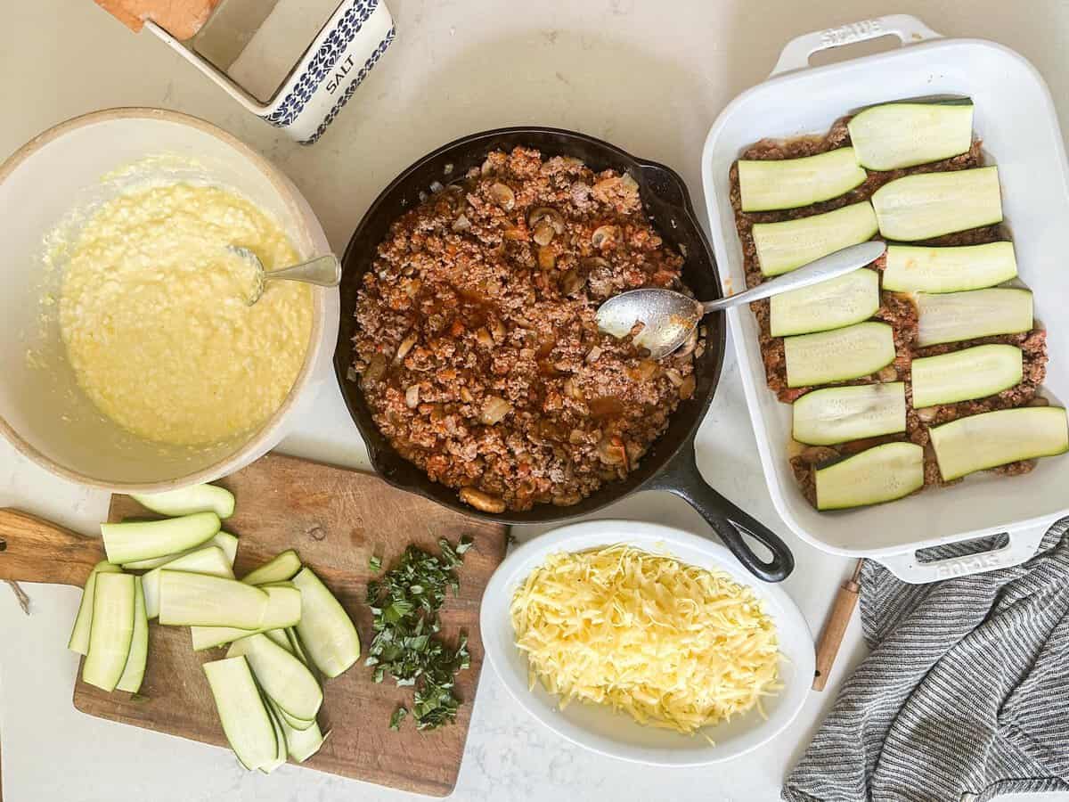 Putting together zucchini lasagna with all the ingredients on the counter.