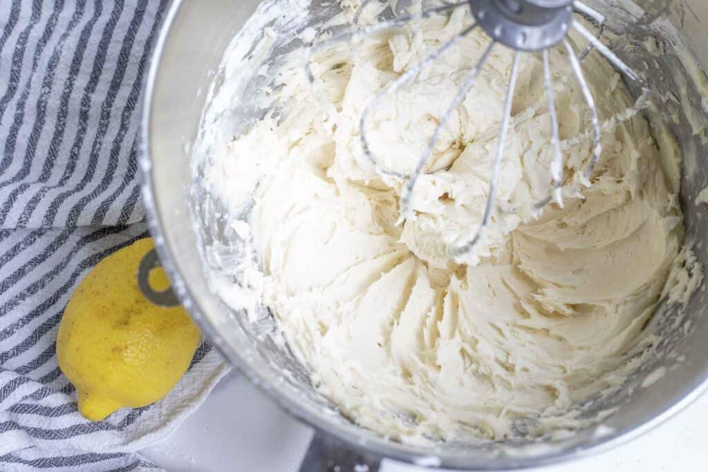 light and fluffy lemon frosting in a stand mixer bowl with whisk attachment. 