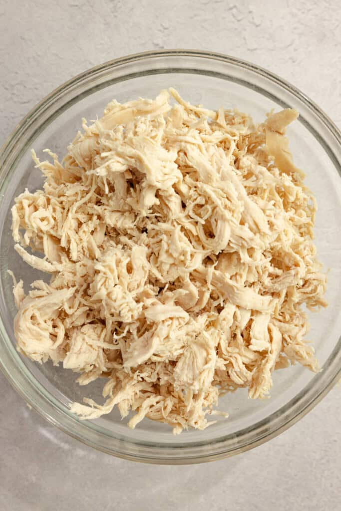 Shredded chicken in a clear bowl.