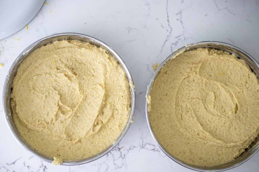 two round cake pans with gluten free lemon cake batter in each pan.