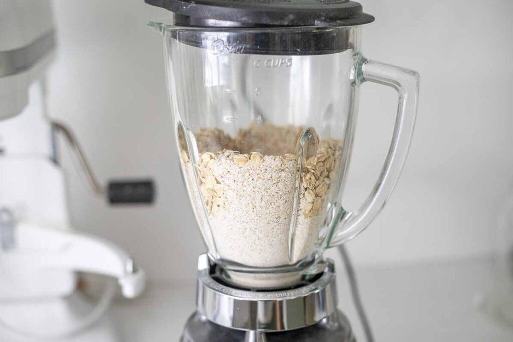 oats blending in a blender to make oat flour.