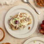 Grape chicken salad on a piece of toast on a white plate.