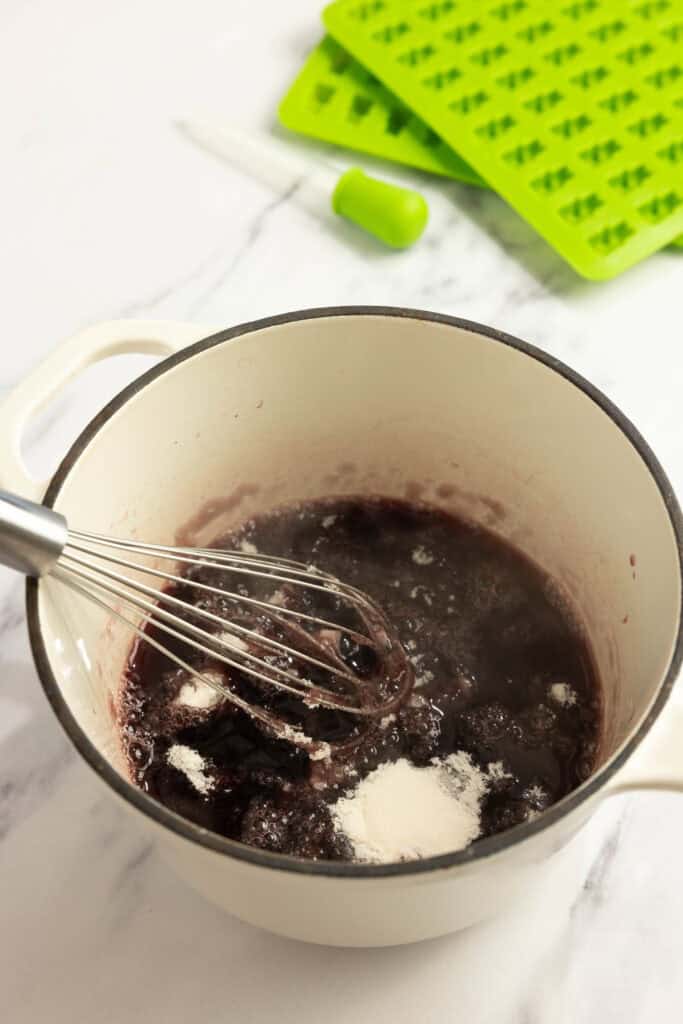 whisking in gelatin into juice in a saucepan.