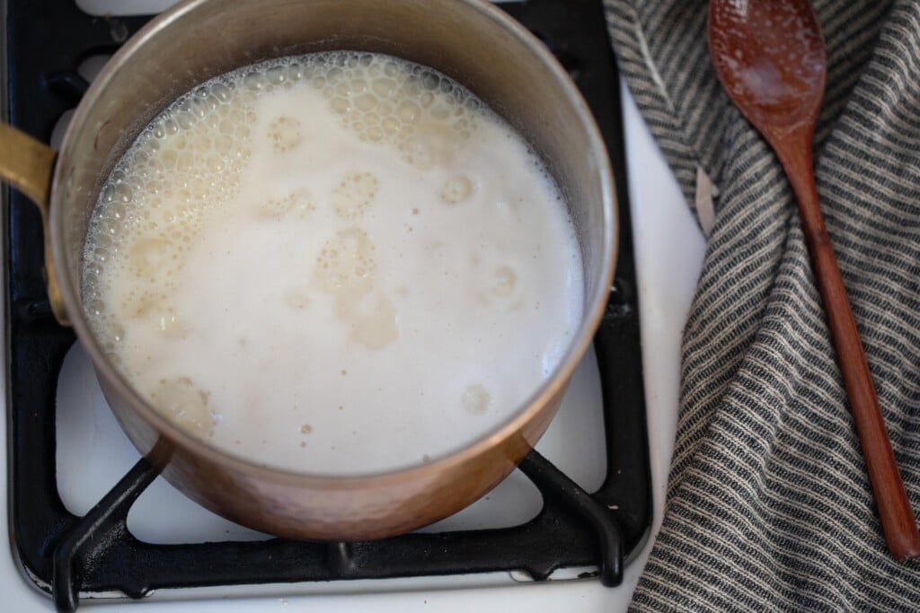 A saucepan of milk and sugar on a low simmer. 