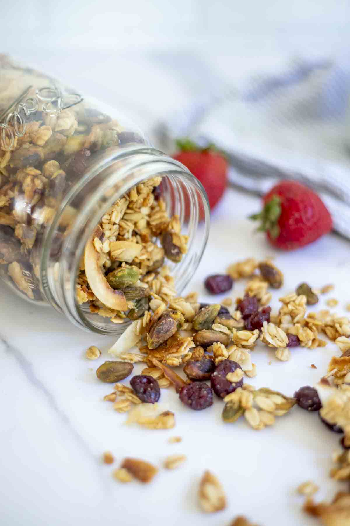 sourdough granola in a jar tipped over on a countertop.