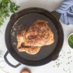 A roasted chicken in a cast iron skillet.