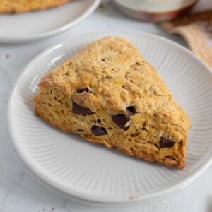 A sourdough scone on a small white plate.