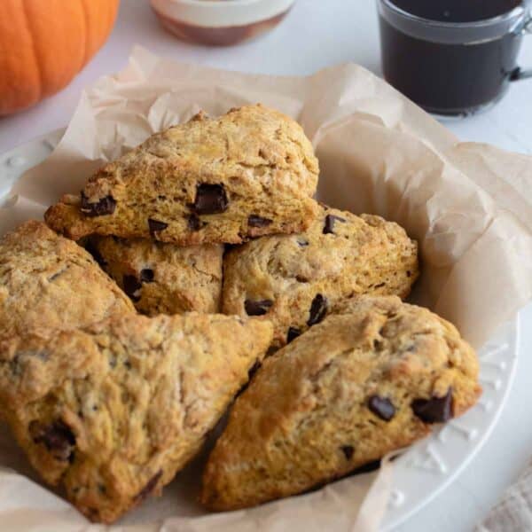 A bowl with a tea towel, filled with pumpkin scones.