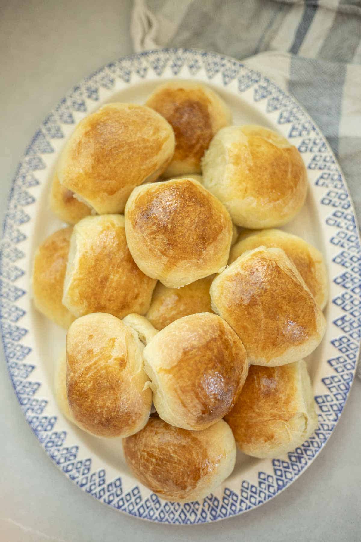 Overhead photo of a blue and white platter filled with sourdough brioche rolls.