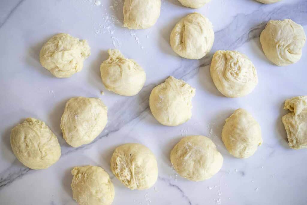 Dough balls on a marble countertop.