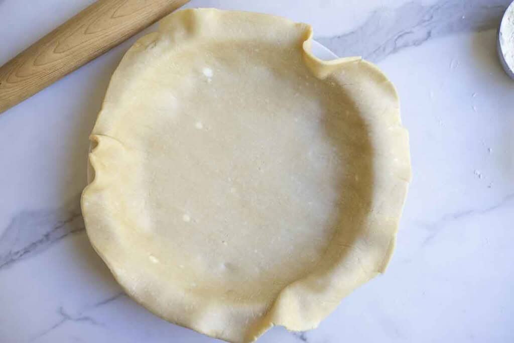 Pie dough rolled out and in a pie plate.