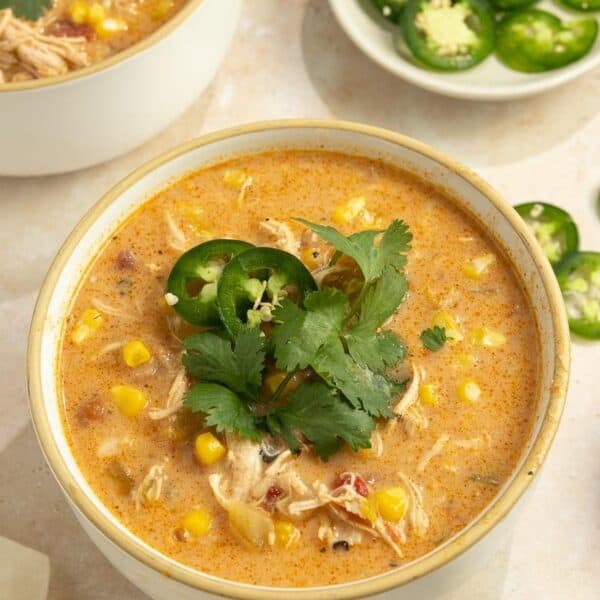 A bowl of white chicken chili topped with jalapeno slices.