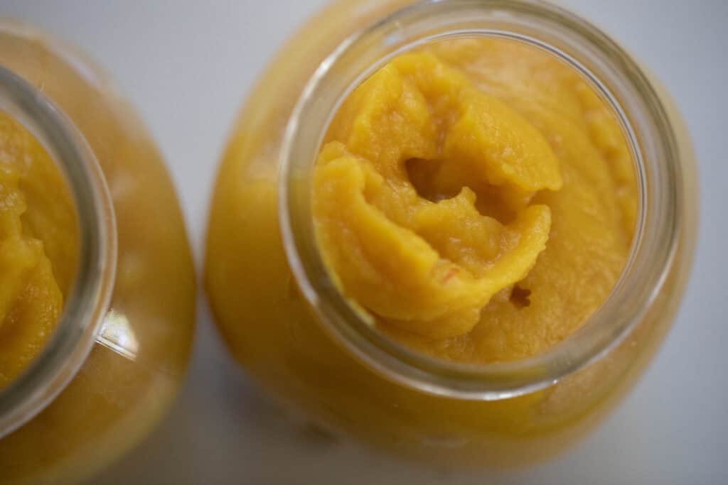 Pumpkin puree in two glass jars.