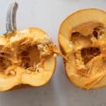 A sugar pumpkin cut in half.