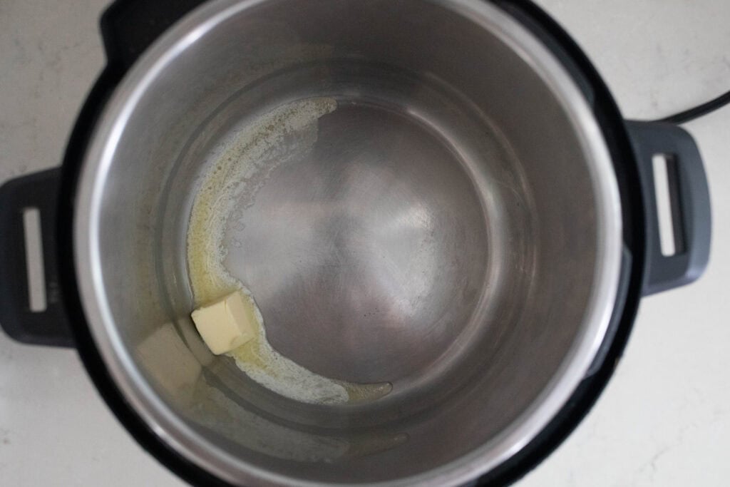 The inside of an instant pot with butter melting.